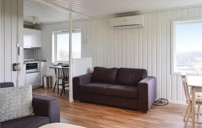 a living room with a couch and a kitchen at 2 Bedroom Cozy Home In Hauglandshella in Kolavåg