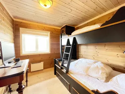 a bedroom with a bed and a desk with a computer at Luxembu - 4 bedroom cabin with a fantastic view in Gol