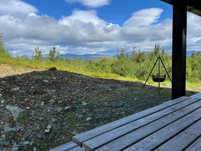 a swing sitting on the porch of a cabin at Linnaeus - 6 person cabin in Ål