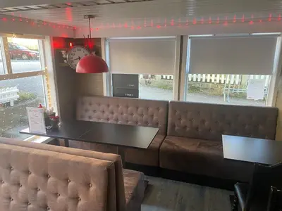 a restaurant with a couch and a table and windows at Frimannsbuda in Selje