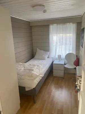 a small bedroom with a bed and a window at Frimannsbuda in Selje