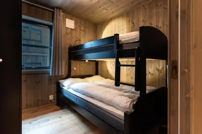 a bunk bed in a room with wooden walls at Trysiltunet 16b in Trysil