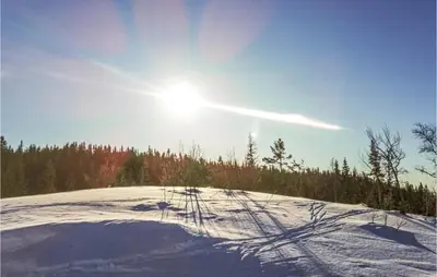 a snow covered hill with the sun in the sky at Cozy Home In Hemsedal With Kitchen in Hemsedal