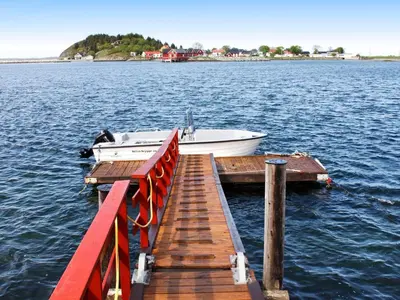 a boat is docked at a dock on the water at 6 person holiday home in Brekstad in Brekstad