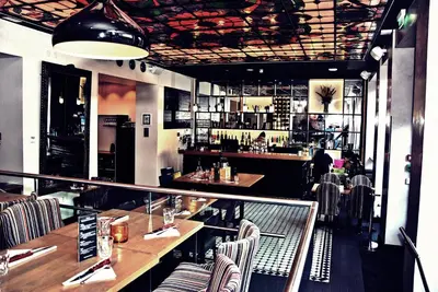 a restaurant with tables and chairs and a bar at Hotel No13 in Bergen