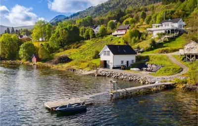 a boat is docked at a dock on a lake at 2 Bedroom Amazing Apartment In Vestnes in Vestnes