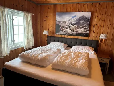 a bedroom with a bed with a picture on the wall at Veslehytta - cabin 1050 moh via amazing view and ambiance in Ål