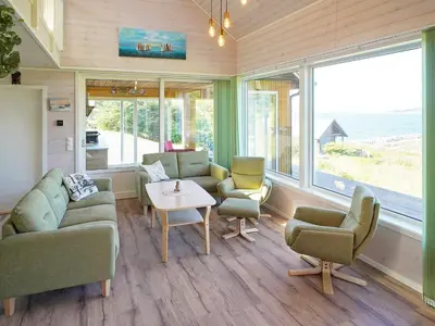 a living room with a couch and chairs and a table at 8 person holiday home in Åram in Sandvik
