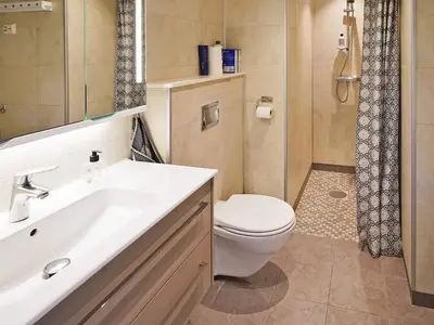a bathroom with a toilet and a sink and a shower at 8 person holiday home in Åram in Sandvik