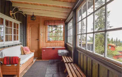 a screened in porch with a bench and windows at Stunning Home In Sjusjøen With Kitchen in Sjusjøen