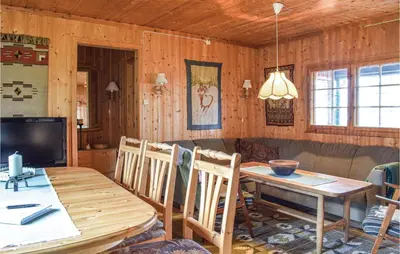 a dining room with a wooden table and a television at Stunning Home In Sjusjøen With Kitchen in Sjusjøen