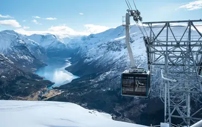 a ski lift with a view of a river and mountains at Hotel Alexandra Loen in Loen