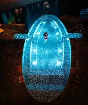 a person in a swimming pool at night at Hotel Alexandra Loen in Loen