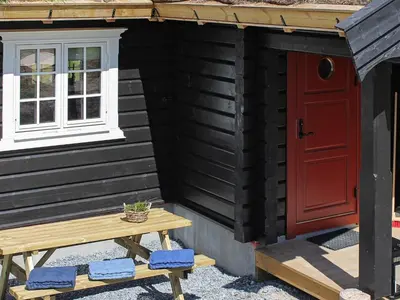 a tiny house with a red door and a bench at 6 person holiday home in Svingvoll in Svingvoll