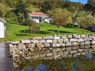 a stone retaining wall in front of a house at Family Oasis with Lake View-By Traum in Ålesund