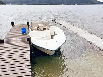 a white boat parked next to a dock at Family Oasis with Lake View-By Traum in Ålesund