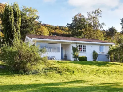 a small white house on a grassy hill at Family Oasis with Lake View-By Traum in Ålesund