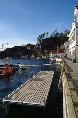 a dock in a body of water with boats at Tysnes Sjø og Fritid in Uggdalseidet