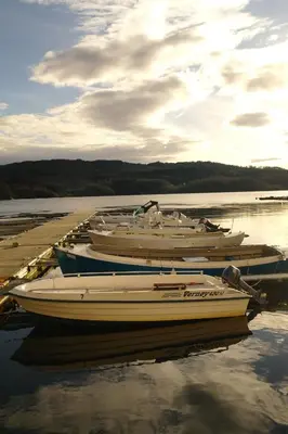 a group of boats docked in the water at Tysnes Sjø og Fritid in Uggdalseidet