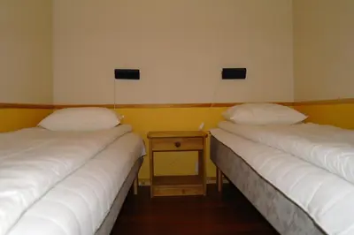 two beds in a room with a table between them at Tysnes Sjø og Fritid in Uggdalseidet