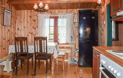 a kitchen with a table and chairs and a refrigerator at 3 Bedroom Nice Home In Venabygd in Venabygd