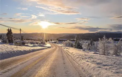 a road covered in snow with the sun in the background at 3 Bedroom Nice Home In Venabygd in Venabygd