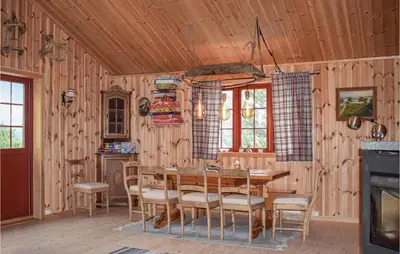 a wooden dining room with a table and chairs at 3 Bedroom Nice Home In Venabygd in Venabygd