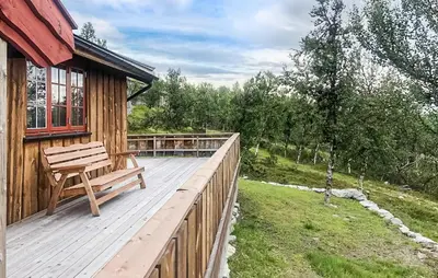 a wooden deck with a bench on the side of a house at 3 Bedroom Nice Home In Venabygd in Venabygd