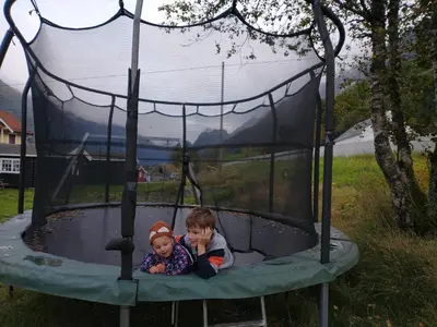 a young boy and a baby playing on a trampoline at Nesset Fjordcamping in Olden