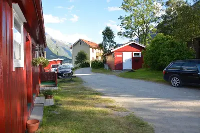 a car parked on the side of a road next to houses at Nesset Fjordcamping in Olden