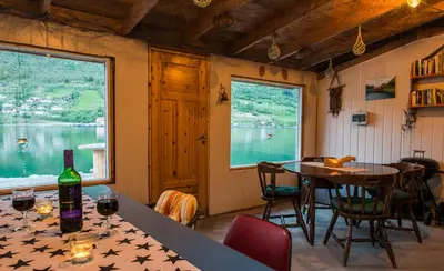 a dining room with a table and a window at Nesset Fjordcamping in Olden