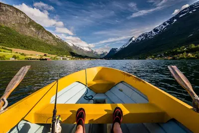 a person is on a yellow boat on a lake at Nesset Fjordcamping in Olden