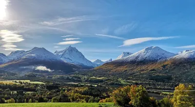 a view of a mountain range with snow capped mountains at Romsdalseggen Lodge in Isfjorden