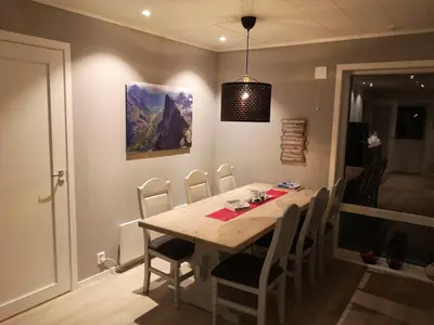 a dining room with a wooden table and chairs at Romsdalseggen Lodge in Isfjorden