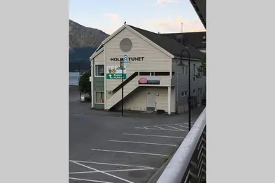 a building with a sign on the side of a street at Balestrand Fjordapartments Holmen 19A in Balestrand