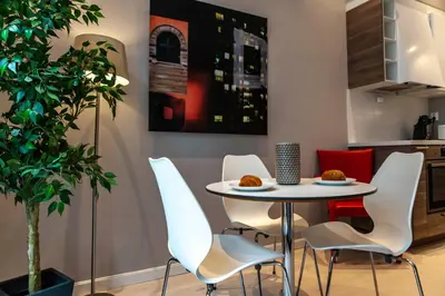 a dining room with a table and white chairs at Forenom Serviced Apartments Bergen City in Bergen