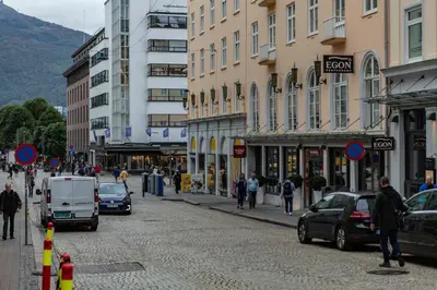 a city street with cars and people walking on the street at Forenom Serviced Apartments Bergen City in Bergen