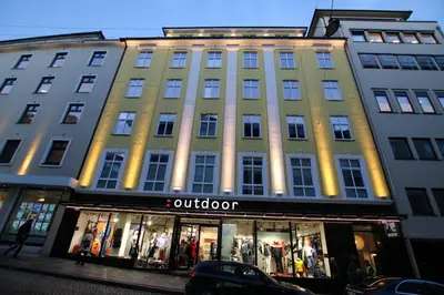 a large building with a store in front of it at Forenom Serviced Apartments Bergen City in Bergen