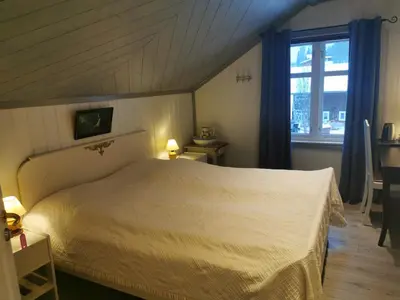 a bedroom with a white bed and a window at Eikre Fjellgård in Hemsedal