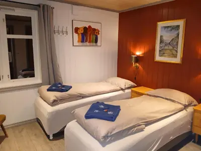 a room with three beds and a window at Eikre Fjellgård in Hemsedal