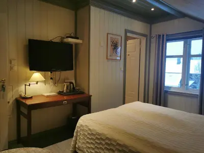 a bedroom with a bed and a desk with a television at Eikre Fjellgård in Hemsedal