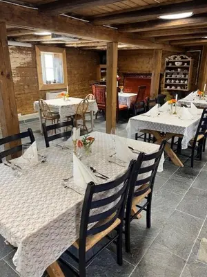 a dining room with tables and chairs with white table cloth at Eidegrend Boutique Hotel in Eikelandsosen