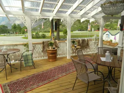 a patio with tables and chairs on a porch at Eidfjord Hytter in Eidfjord