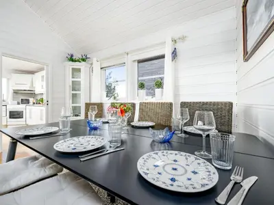 a dining room with a black table and chairs at Holiday Home Sjøbuvågen by Interhome in Korssund