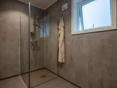 a shower with a glass door and a window at Holiday Home Brosme by Interhome in Bømlo