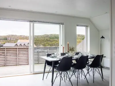 a dining room with a table and chairs and a large window at Holiday Home Brosme by Interhome in Bømlo