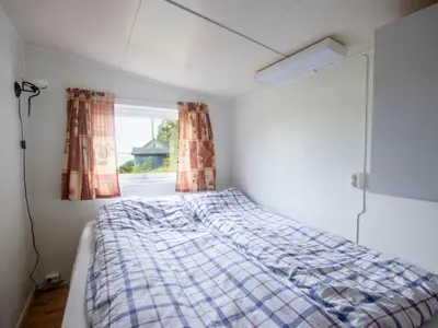 a bed in a room with a window at Holiday Home Fjordglytt by Interhome in Onarheim