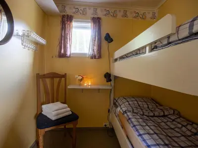 a bedroom with a bunk bed and a chair at Holiday Home Fjordglytt by Interhome in Onarheim