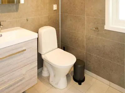 a bathroom with a white toilet and a sink at Holiday Home Nesholmen by Interhome in Leirvik