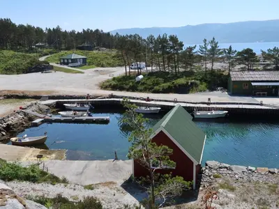 a group of boats in a harbor with a dock at Holiday Home Nesholmen by Interhome in Leirvik